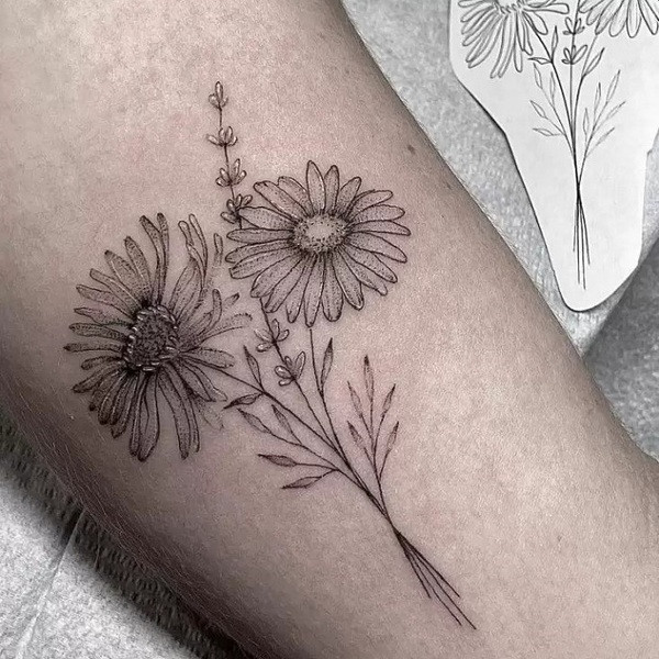 Aster flower and moon tattoo design, combining floral beauty with celestial mystery, on the upper back.