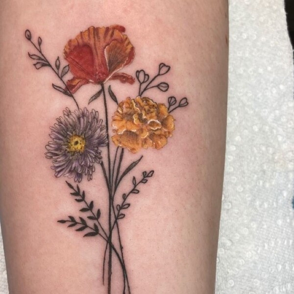 Tiny aster flower tattoo, extremely small and delicate, placed on the finger.