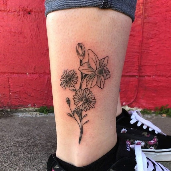 Realistic black and gray aster flower tattoo, focusing on detailed shading and texture, on the upper arm.