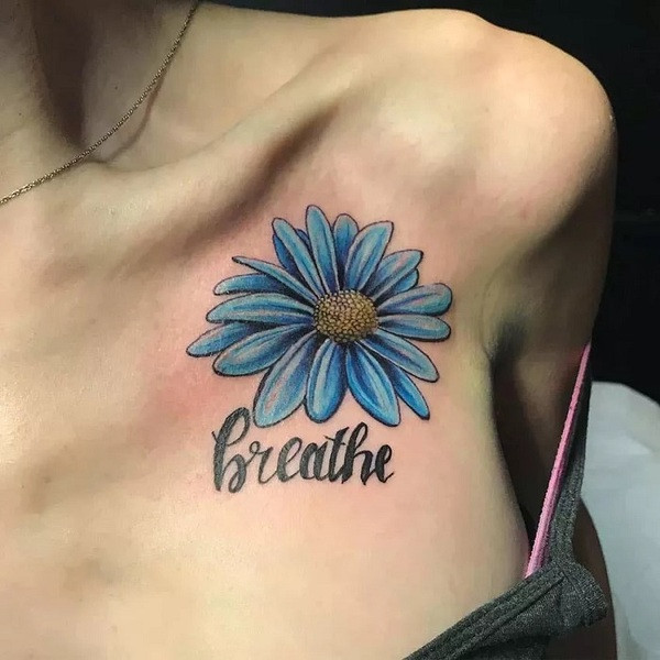 White ink aster flower tattoo, subtly visible on lighter skin tones, creating a delicate and ethereal effect, on the shoulder blade.