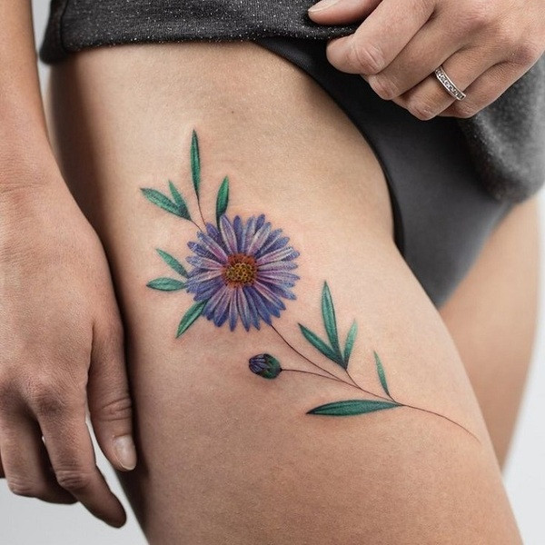 Botanical style aster flower tattoo, accurately depicting the flower with scientific detail, on the calf.