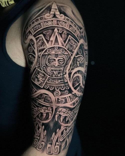 Aztec tribal tattoo on a man's chest, displaying geometric patterns and possibly a stylized Aztec deity.