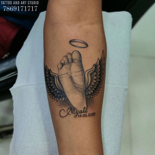 Sentimental baby footprint tattoo with angel wings, symbolizing birth, innocence, and remembrance of a child.