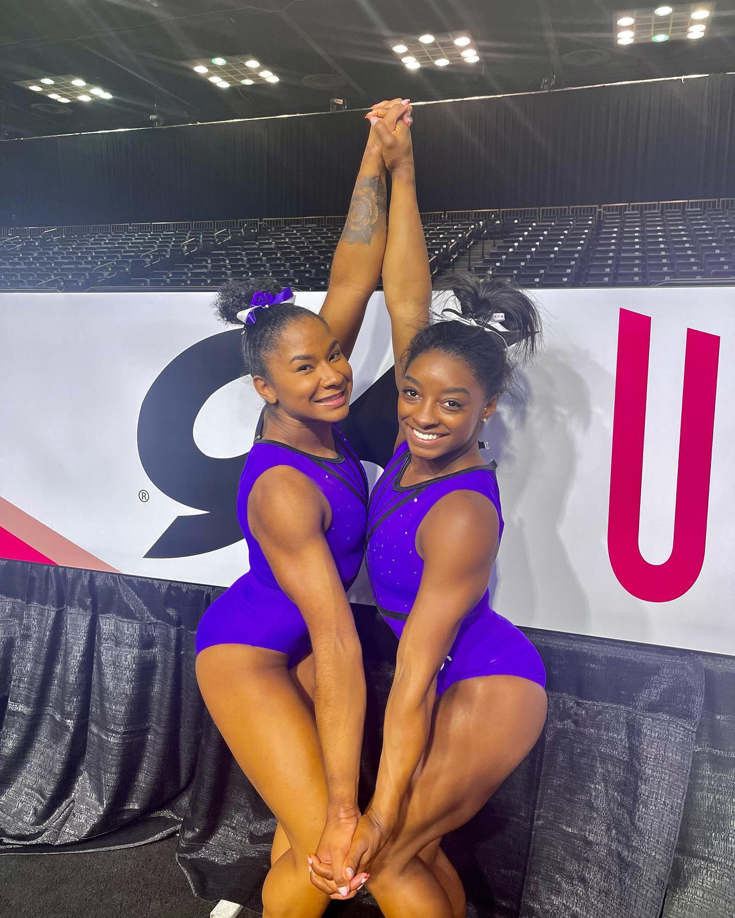 Jordan Chiles displays her rose tattoo on her left wrist while posing with Simone Biles in matching leotards.