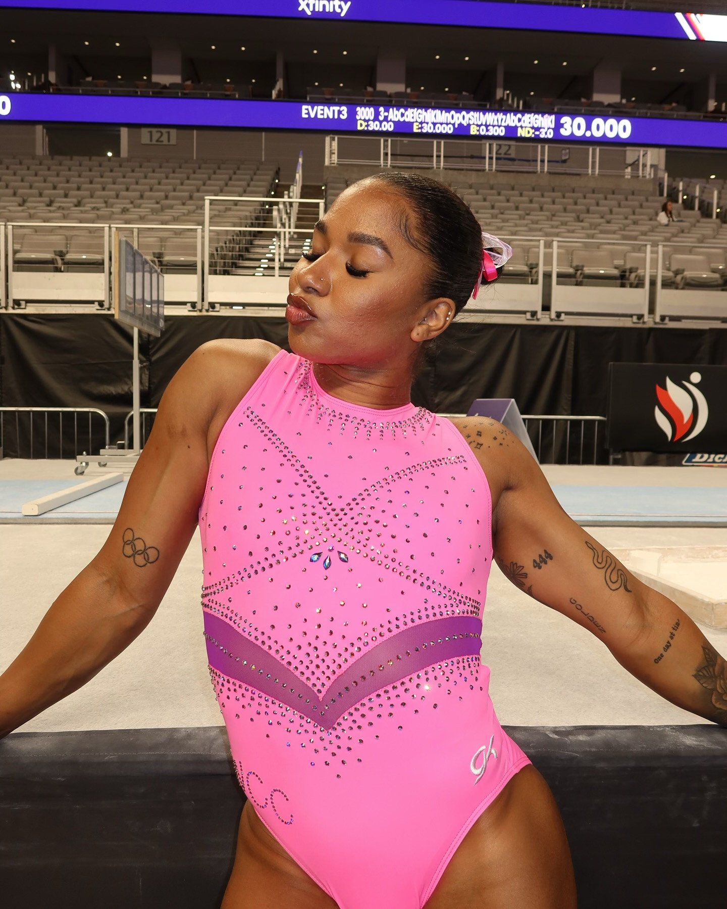 Jordan Chiles proudly displays her Olympic rings tattoo on her right arm in a pink leotard.