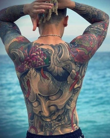 A Japanese-style dragon tattoo design across a man's back shoulder area