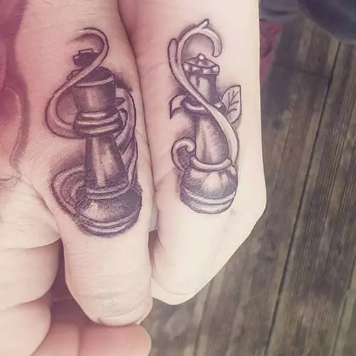 Chess icons for king and queen tattoos on thumbs