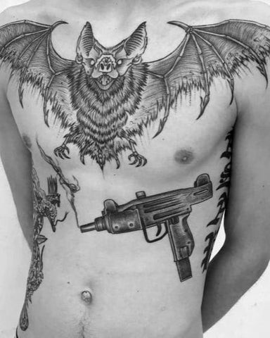 Man with a bat chest tattoo featuring a bat with wings spread