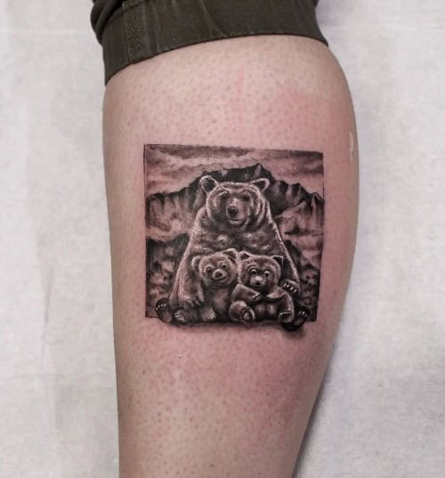 Mother bear and cubs silhouette tattoo on a man's shoulder, celebrating maternal love and family protection.