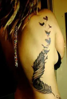 Light and airy feather tattoo on the ribs symbolizing freedom