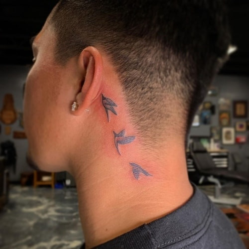 Behind the ear tattoo with a dragon design, a unique and edgy men tattoo idea.