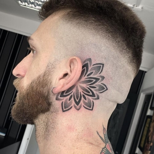 Behind the ear tattoo with a small symbol, a discreet and meaningful men tattoo idea.