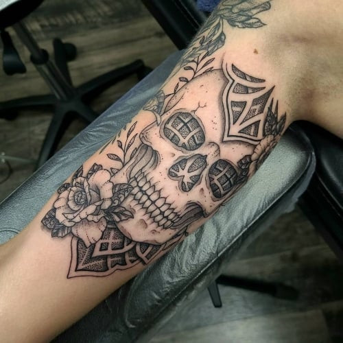 A bicep tattoo with bold lines and geometric shapes on a man's arm, enhancing muscle