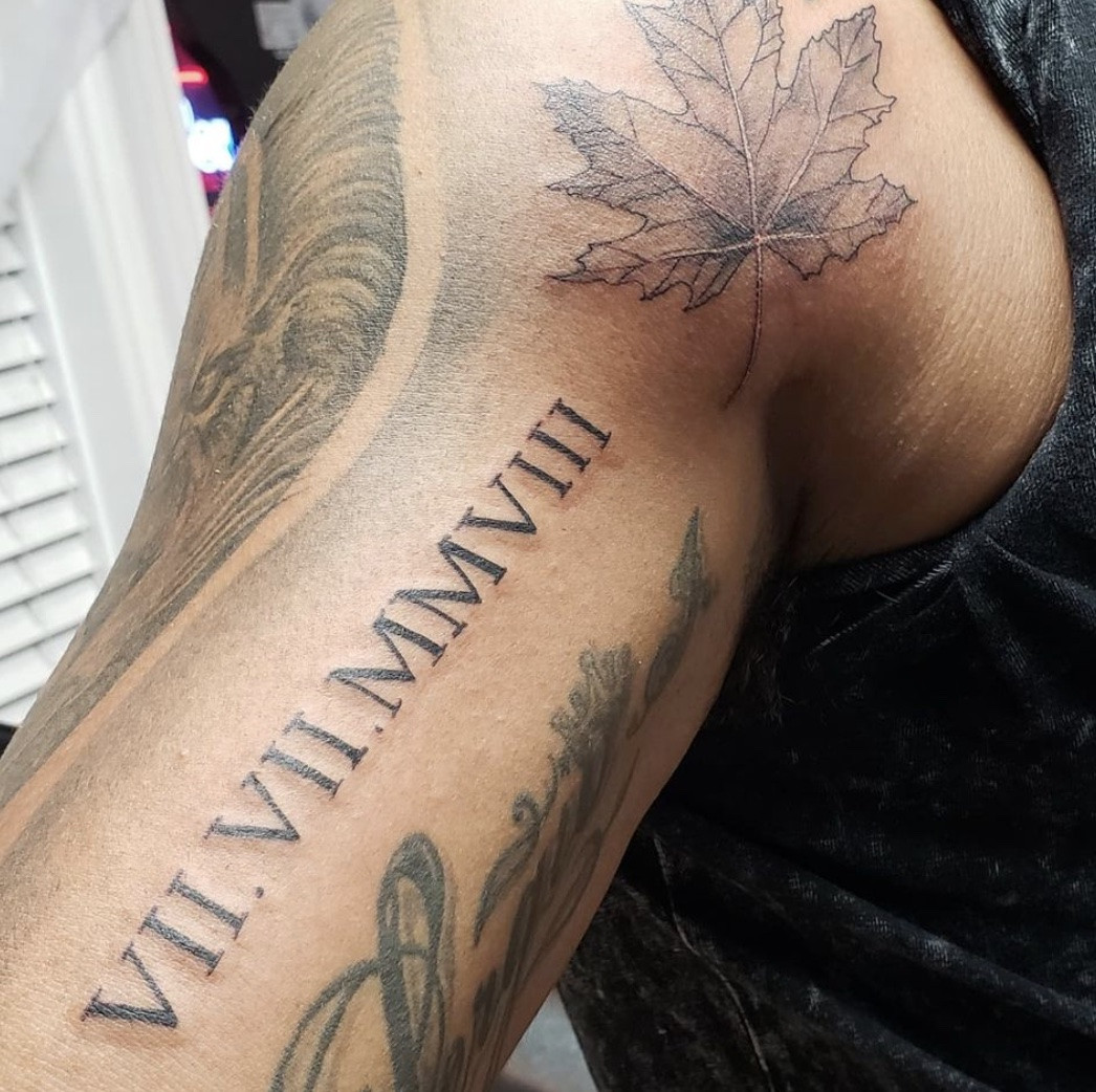 Bold Roman Numeral Tattoo on a man's bicep