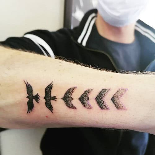 Minimalist bird silhouette tattoo for men, representing spirituality and personal freedom