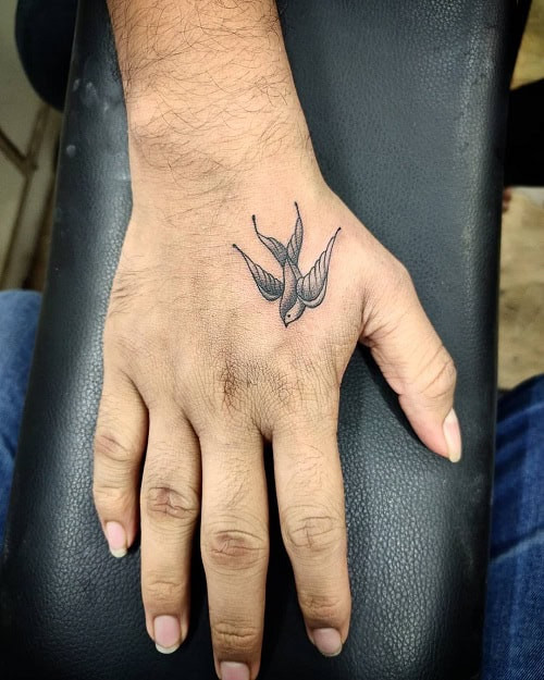 Visible bird tattoo for men on the hand, a constant reminder of freedom and personal values