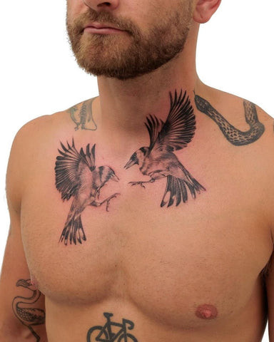 Man with a bird chest tattoo featuring a detailed bird in flight