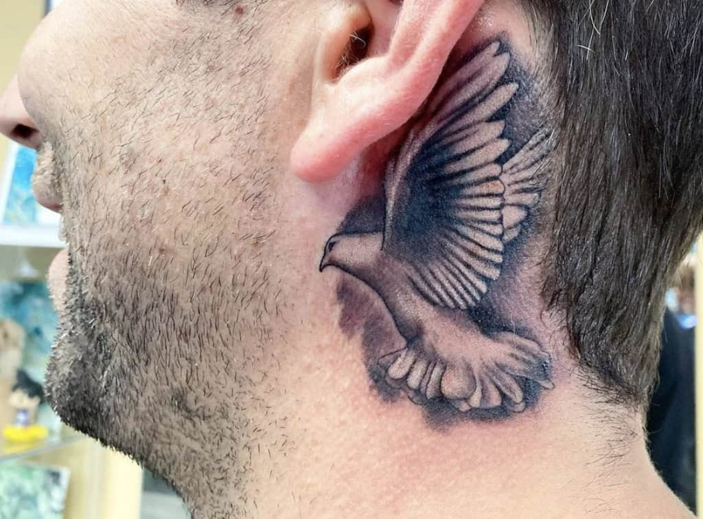 Discreet bird tattoo for men behind the ear, a subtle and personal expression of freedom
