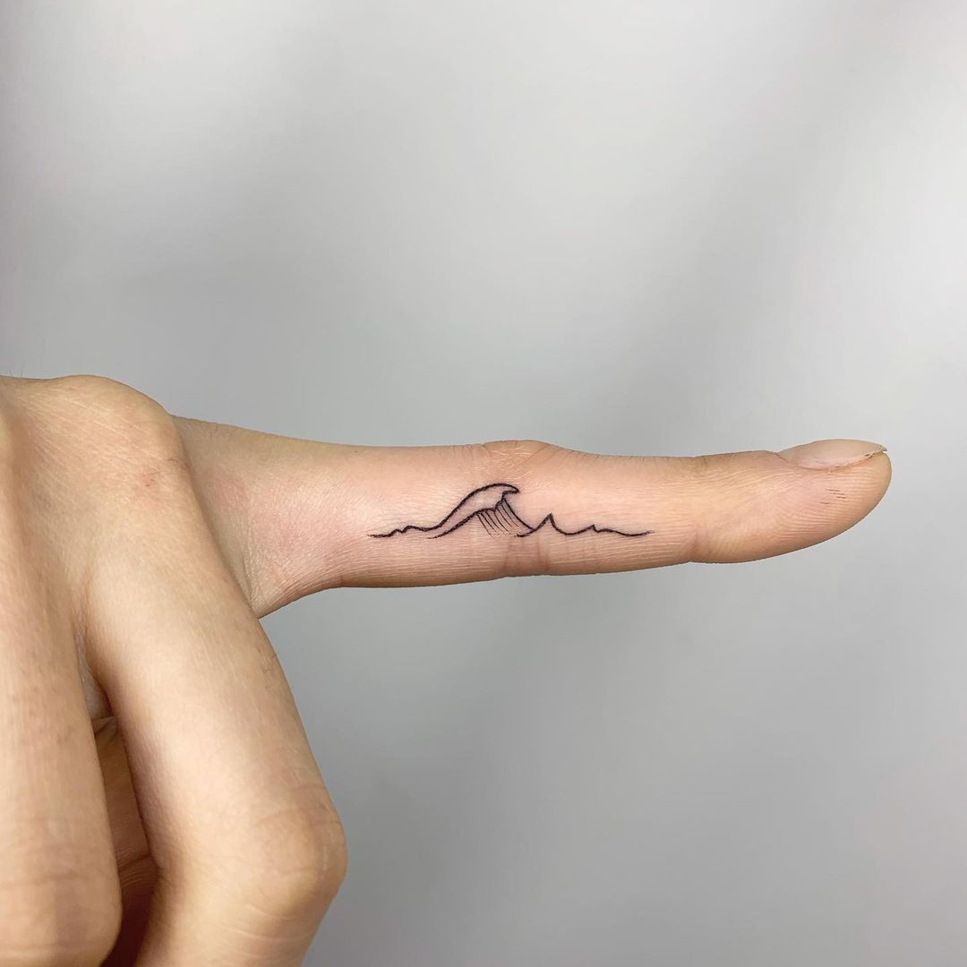 Wave tattoo on finger, minimalist and ocean-inspired design