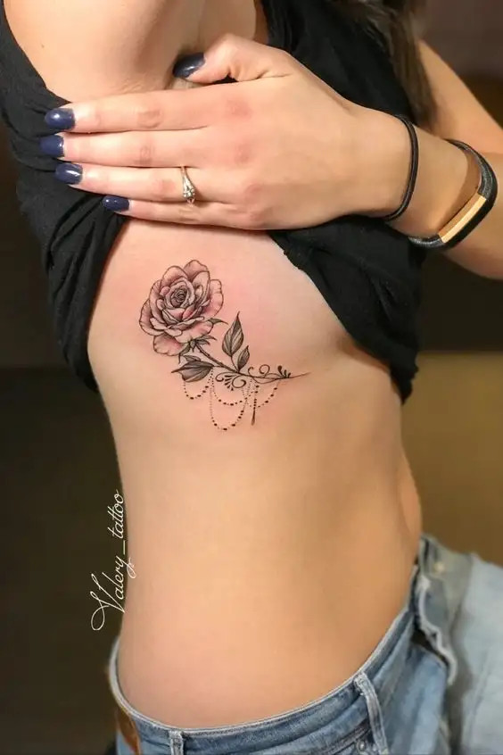 Elegant botanical tattoo on the rib cage featuring flowers and plants