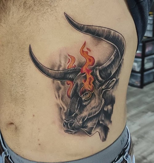 Black ink Brahma bull tattoo with detailed shading on the upper arm