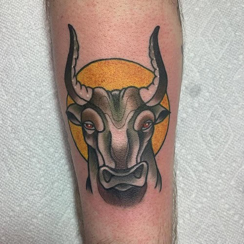 Black and grey ink bull head tattoo on the upper arm