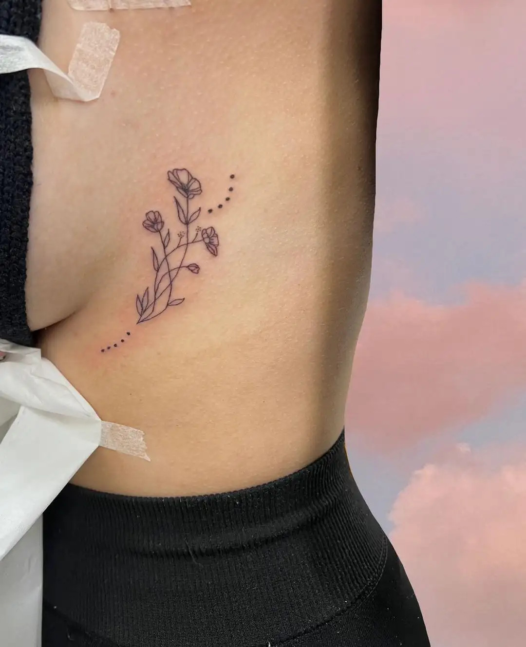 Delicate buttercup flower tattoo on the ribs for a feminine touch