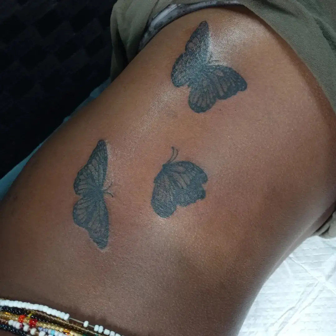 Elegant butterfly tattoo on woman's rib cage symbolizing transformation