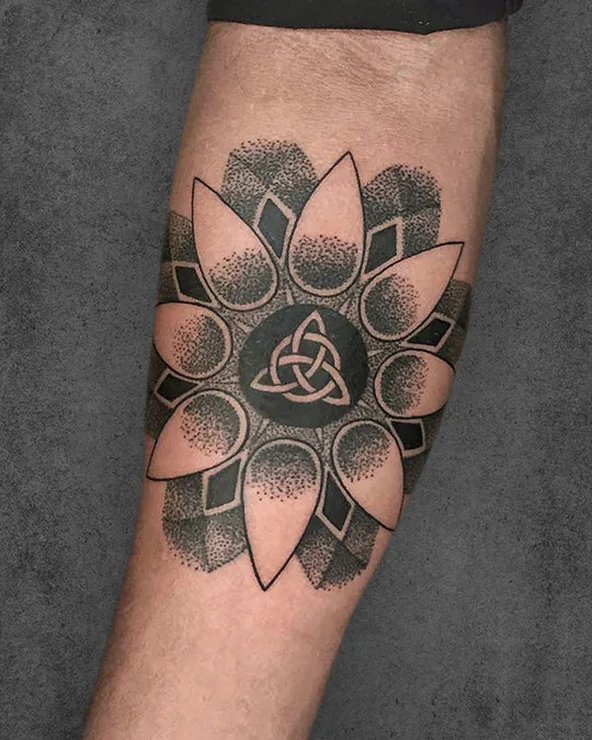 Celtic knot interwoven with a Flower of Life tattoo, blending cultural symbolism and geometric harmony in a unique design.