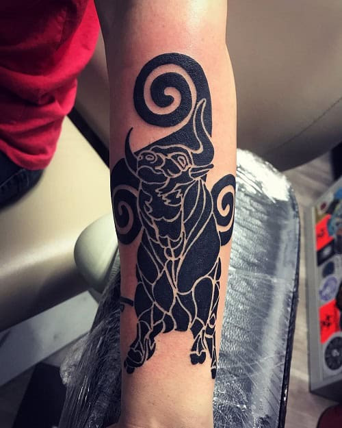 Celtic knotwork style bull tattoo in black ink on the forearm
