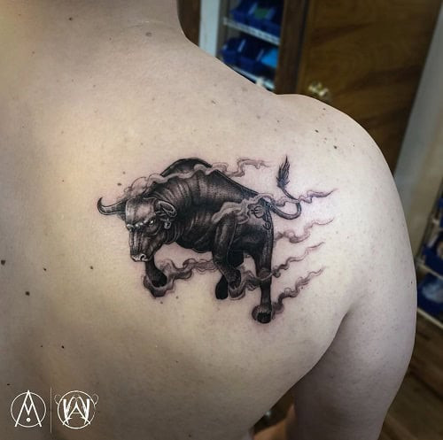 Black ink charging bull tattoo with motion lines on the calf