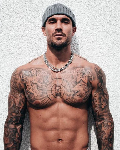 A man with a full chest piece tattoo that covers the entire chest area with an intricate and detailed design.