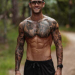 Muscular man with a detailed chest tattoo featuring a lion and geometric patterns