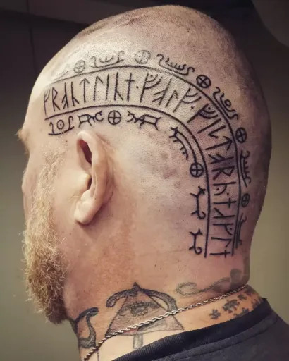 Detailed Viking head tattoo featuring knotwork and runic symbols covering the scalp.