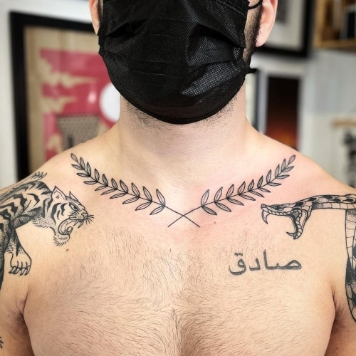 A collarbone tattoo with symbols on a man's upper chest, discreet and meaningful