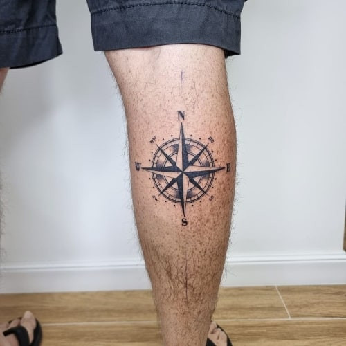 Nautical compass tattoo with map details on a man's arm