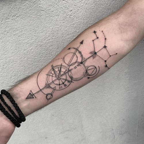 Intricate compass and map tattoo on the arm, ideal men tattoo ideas for travelers.