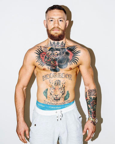 Conor McGregor chest tattoo featuring a crowned gorilla eating a heart