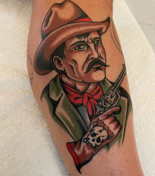 Cowboy riding a horse tattoo on the arm, symbolizing freedom in men tattoo ideas.