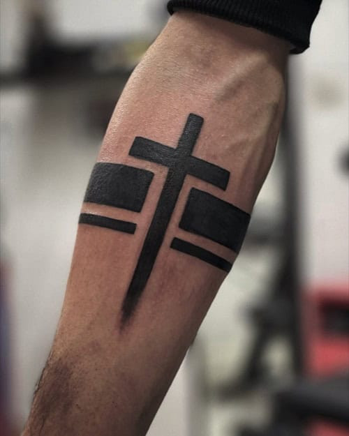 Detailed cross forearm tattoo in black ink