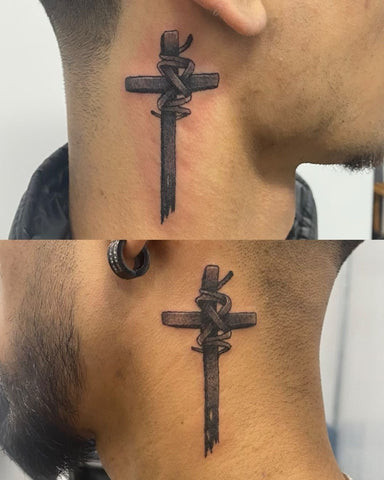 Small black cross tattoo behind a man's ear, subtle and hidden placement.