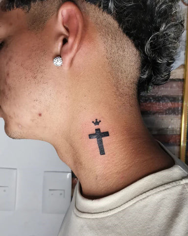 Simple line cross tattoo behind a man's ear, minimalist and delicate design.