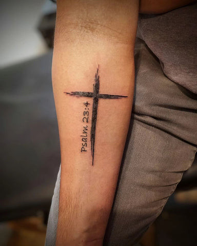 Simple black ink cross tattoo on a man's forearm, minimalist and clean design.