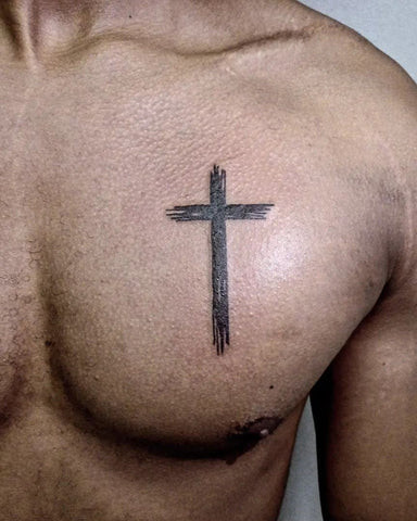 Detailed religious cross tattoo on a man's chest, featuring intricate details and symbolism.