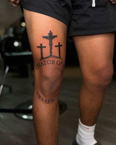 Detailed cross tattoo on a man's calf, incorporating shading and intricate linework.