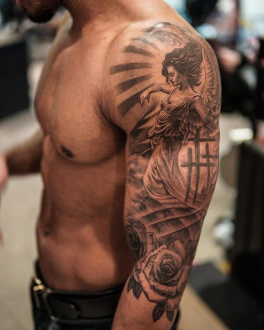 A Celtic cross tattoo on a man's upper shoulder