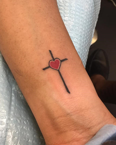 Small shaded cross tattoo on a man's wrist, adding depth and dimension to a minimalist design.