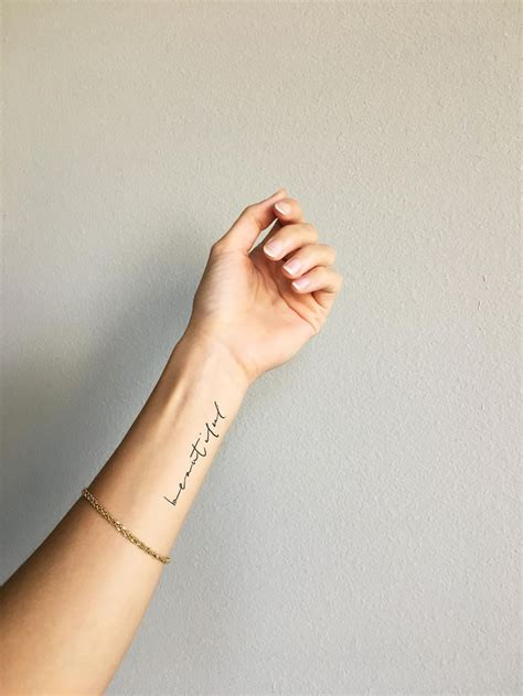 Elegant Cursive Tattoo Placement on Wrist