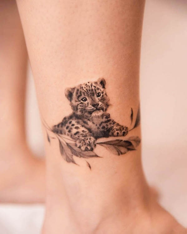 Cute cheetah ankle tattoo, emphasizing the adorable side of a cheetah with sparkling eyes and a lively expression