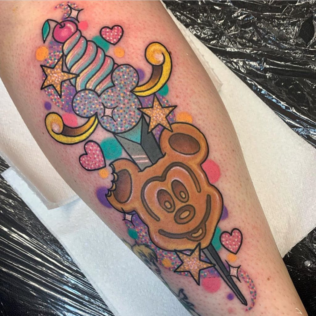 A traditional dagger tattoo re-imagined with cute and colorful elements, featuring bright gems and playful details.